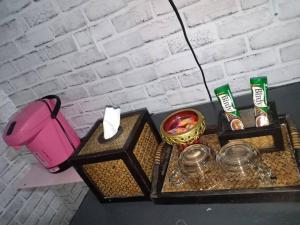 Prakhon Chaiเซราะกราว บูติก รีสอร์ท Sohground Boutique Resort的一张桌子,上面有两篮子的食物和粉红色的搅拌机
