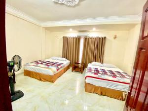 下龙湾越南下龙百谐酒店的一间卧室配有两张床和吊灯。