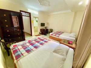 下龙湾越南下龙百谐酒店的酒店客房,设有两张床和镜子