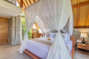 乌布Lasamana Villas Ubud by Pramana Villas的一间卧室配有一张带天蓬的白色床