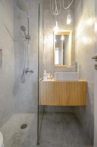 米科利维亚亚德瑞斯公寓的一间带水槽、镜子和淋浴的浴室
