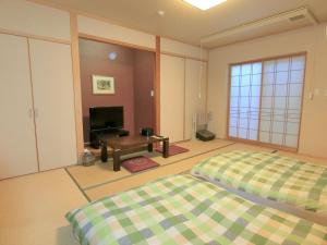 宫崎浴拉宽宫崎酒店的一间卧室设有两张床、一台电视和一张桌子