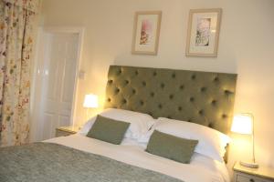 斯卡伯勒科迪莉亚酒店的一间卧室配有一张大床和两个绿色枕头
