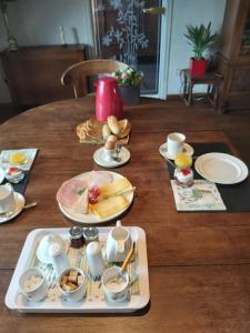 迪斯特阁楼住宿加早餐旅馆的木桌,上面有盘子和杯子,盘子