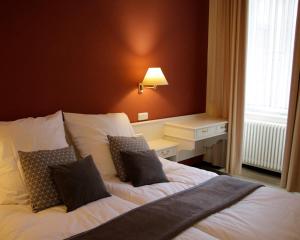 特里尔Z&B Hotel的一间卧室配有带白色床单和枕头的床。