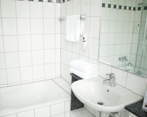 特里尔Z&B Hotel的白色的浴室设有水槽和浴缸。