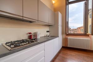 威尼斯莫罗西尼总督宫公寓的厨房配有炉灶、水槽和窗户。