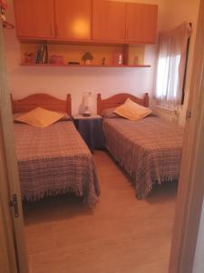 Navas de EstenaCasa Simona的一间卧室配有两张床和一张带台灯的桌子