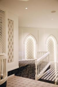 Prakhon ChaiHotel de l'amour SHA PLUS的走廊设有两个拱形窗户和楼梯