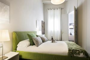 巴塞罗那Ola Living Gaudi的一间卧室配有一张带绿色床头板的床