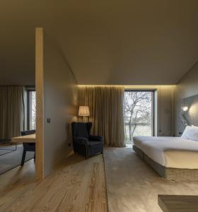 阿马兰特Monverde - Wine Experience Hotel - by Unlock Hotels的卧室配有床、椅子和窗户。
