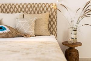 纳克索乔拉Hotel Villa Flora的一张带枕头的床和一张桌子上的植物