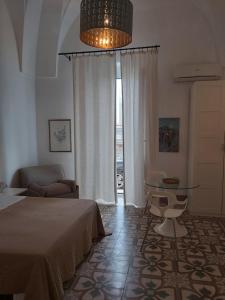曼杜里亚Civico 2的一间卧室配有一张床、一张沙发和一张桌子