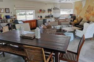 MalgasStaples House - Living The Breede的一个带木桌和椅子的大客厅