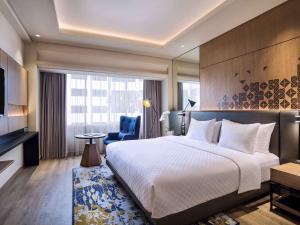 雅加达Mercure Jakarta Batavia的酒店客房设有一张大床和一台电视。