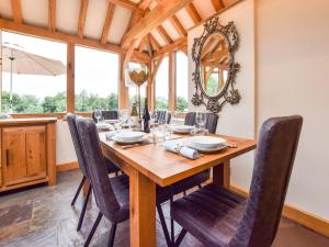 MinchinhamptonHyde Tyning Cottage的一间带木桌和椅子的用餐室
