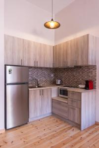 科罗尼MARKOS LUXURY APARTMENTS的厨房配有木制橱柜和不锈钢冰箱。