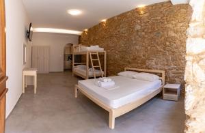 科罗尼MARKOS LUXURY APARTMENTS的一间卧室设有一张床和石墙