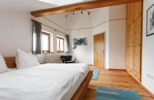 萨尔察赫河畔戈灵Ferienwohnung am Bründlweg的卧室配有一张白色的大床,铺有木地板