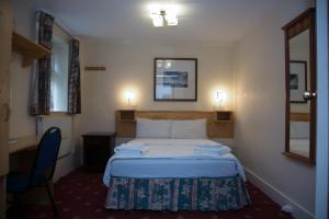 伦敦桥园酒店的酒店客房带一张床、一张书桌和一面镜子