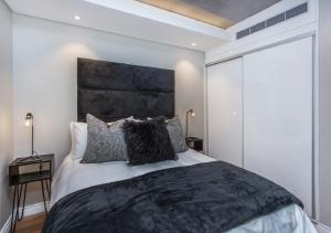 开普敦Docklands Deluxe One bedroom Apartments的一间卧室配有一张大床和黑色床头板