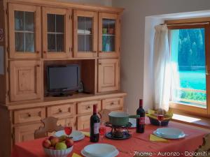 奥伦佐卡多利7home的厨房配有桌子、电视和一些葡萄酒瓶