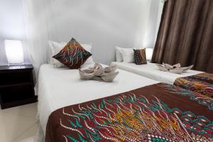 利文斯顿Nzubo Experience的两张位于酒店客房的床,配有毛巾