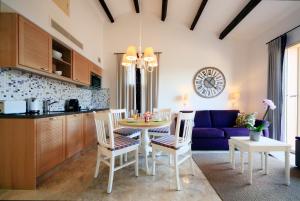 拉马德拉戈Hapimag Apartments La Madrague的厨房以及带桌椅的用餐室。