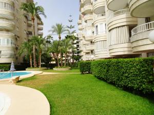 洛斯马蒂雷斯TROPICANA GANDIA - Alquiler sólo Familias的一座大型公寓楼,设有一座庭院,毗邻一座游泳池