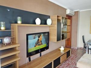 洛斯马蒂雷斯TROPICANA GANDIA - Alquiler sólo Familias的客厅设有壁挂式平面电视。