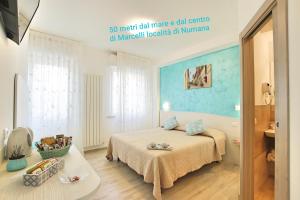 努马纳Affittacamere I Principi del Conero CIR 00041的一间卧室配有一张蓝色墙壁的床