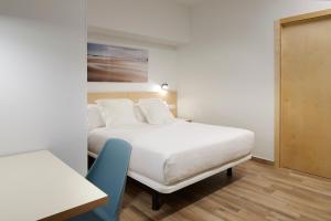 扎鲁亚斯Apartamentos Isaga的一间卧室配有两张床和一张蓝色椅子