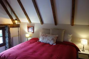 Le cottage du Coudray, gîte avec chalet sauna的一间卧室配有一张带红色毯子的大床