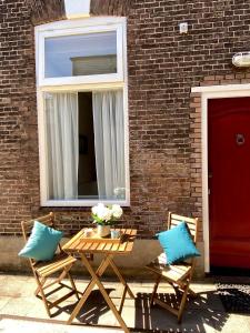 斯海弗宁恩Basic Little House Scheveningen的一张带两把椅子的木桌和窗户