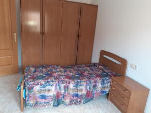 AlmenarCasa URIN的一间卧室配有一张床和一个木制橱柜