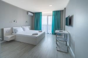 巴统Orbi Residence Hotel Official的卧室配有白色的床和绿色窗帘