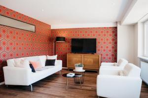 科尔马LE 19 KLEBER climatisé的客厅配有2张白色沙发和电视