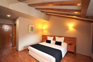 奥尔迪诺Hotel & SPA Niunit的卧室配有带枕头的大型白色床