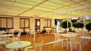 蓬塔翁布里亚阿雅蒙提诺酒店的一间设有桌子和白色椅子的房间