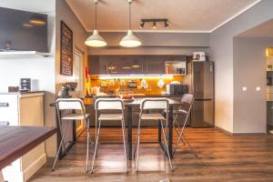 蓬塔德尔加达Atlantic Home Azores的厨房设有酒吧,里面摆放着凳子