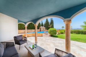圣费德洛斯博利什Villa Mimosa sleeps 8 with Heated Pool的一个带桌椅的室内庭院和一个游泳池