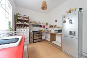 墨西哥城Casa Índigo CDMX的厨房铺有木地板,配有白色冰箱。