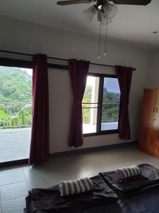 清莱DOI TUNG Anisa Homestay的一间卧室设有一张床和一个大窗户