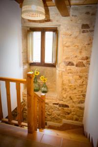 拉林Miña Nai, Casa Rural的一间设有楼梯的房间,一个窗户和花瓶