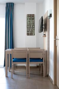 普拉亚登博萨维斯塔马二号公寓酒店的一张带蓝色椅子的餐桌和一台电视