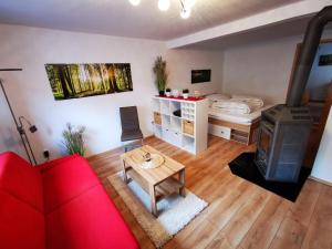 HunswinkelFerienappartement -Hof Baum的客厅配有红色的沙发和床。