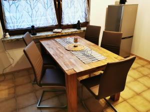 HunswinkelFerienappartement -Hof Baum的厨房里设有一张木桌,周围摆放着椅子
