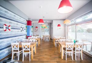 库瑞尼卡慕斯卡Porto Marina的餐厅设有木桌、椅子和红色灯具