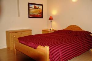 基洛纳鹌鹑岭度假天堂住宿加早餐旅馆的一间卧室配有一张带红色条纹棉被的床
