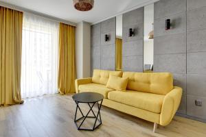 格但斯克Angielska Grobla Apartinfo Apartments的客厅配有黄色的沙发和桌子